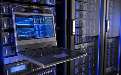 A technician's laptop connected to a server rack